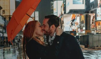 A couple kissing under an umbrella in New York's Time Square