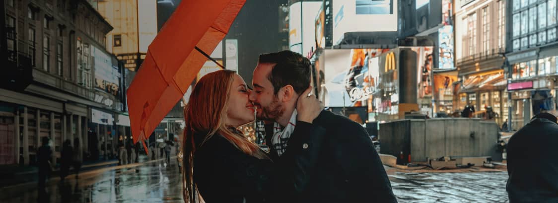 A couple kissing under an umbrella in New York's Time Square