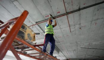 Construction worker on scafording working on ceiling