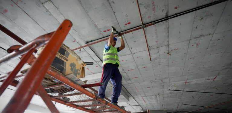 Construction worker on scafording working on ceiling