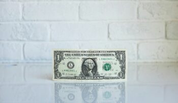 Dollar bill on white brick background